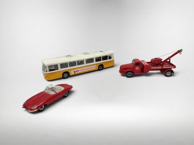 trois petites voitures placées à côté d'un bus et d'une voiture