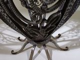 a metal sculpture of a bird on a white table