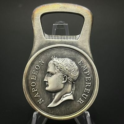 une image représentant un décapsuleur sur lequel repose une pièce de monnaie