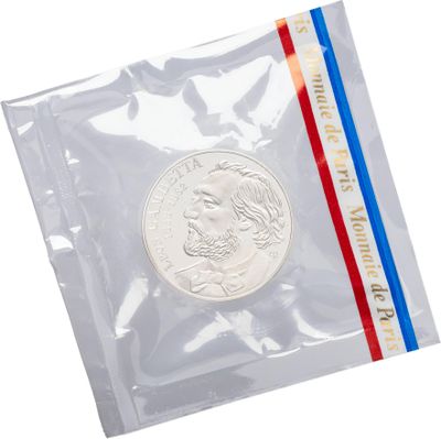 a close up of a coin in a plastic bag on a white background