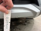 someone is measuring the height of a car with a tape