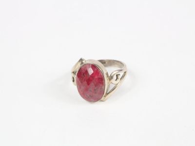 une bague en argent avec une pierre rouge au centre