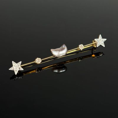 a close up of a pair of star and pearl hair pins