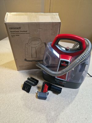 un aspirateur posé sur le sol à côté d'une boîte