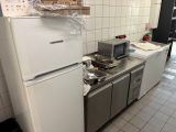 a kitchen with a refrigerator, stove, microwave, and other appliances