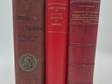trois livres rouges superposés sur une surface blanche