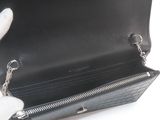 someone is holding a black purse with a chain around it