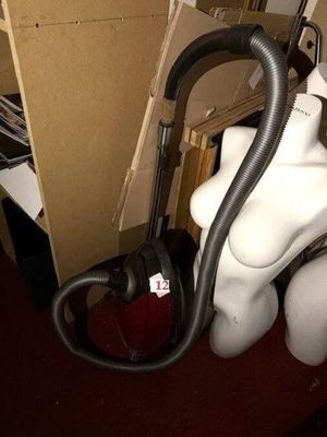 un mannequin blanc avec un aspirateur dans une pièce