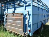 a blue trailer that is parked in the grass