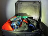 a suit case filled with clothes and a bottle of water