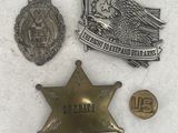 three badges and a badge are laying on a white surface