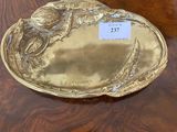 a gold plate on a wooden table with a name tag on it