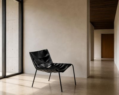 une chaise noire placée dans une pièce dotée d'une grande fenêtre