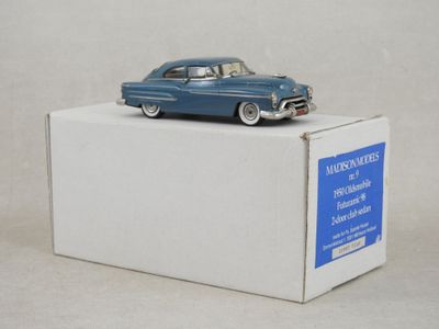 une petite voiture bleue posée sur une boîte blanche