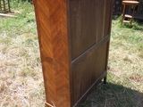 une grande commode en bois posée au milieu d'un champ