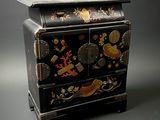 une commode noire ornée d'un motif