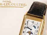 an image of a gold watch with a black leather strap