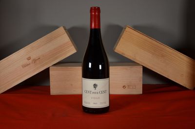 a bottle of wine sitting on a table next to two wooden boxes