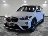 La BMW X1 est garée dans un showroom au sol à damier.