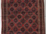 a red and black rug on a white floor