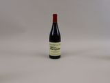 une bouteille de vin à côté d'un verre de vin