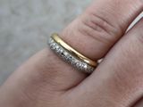la main d'une femme tenant une bague en or et en argent