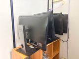 deux écrans d'ordinateur posés sur un bureau en bois