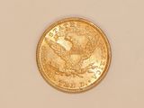 a close up of a gold coin on a white surface