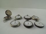 many different types of pocket watches sitting on a table
