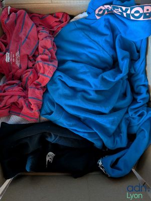 a box full of clothes that is sitting on the floor