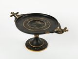 a black and gold plate with a bird on it