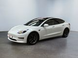 a white tesla model 3 parked in a white room