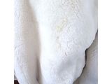 a white teddy bear that is laying down on a chair