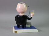 a figurine of a man holding a glass of wine
