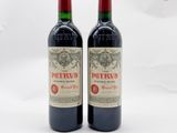 deux bouteilles de vin rouge posées l'une à côté de l'autre sur une surface blanche