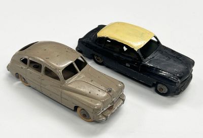 deux voitures jouets assises l'une à côté de l'autre sur une surface blanche