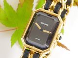 a black and gold watch with a chain around it