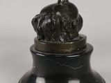 bronze statue of a man on a rock with a bird on top