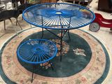 a blue table with two umbrellas on it in the middle of a room