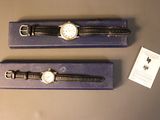 two watches that are on display in a purple box