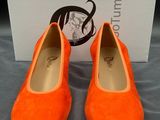 une paire de chaussures orange posée sur une boîte