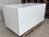 white chest of drawers in a warehouse with pallets of wood