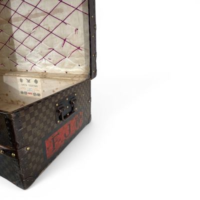 une vieille valise ouverte posée sur une surface blanche