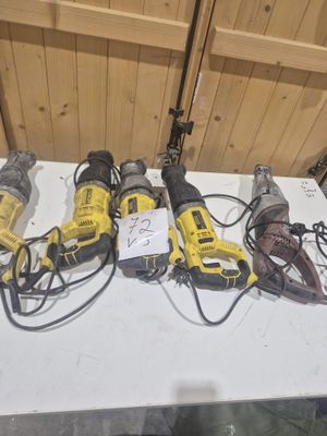 Plusieurs outils électriques sont alignés sur une table dans une pièce.