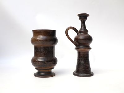 two vases sitting next to each other on a white surface