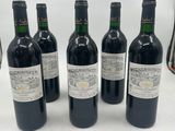 six bottles of wine are lined up on a table