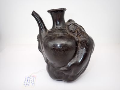 un vase noir orné d'un oiseau, posé sur une table