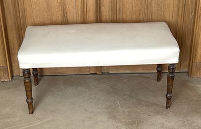 un banc blanc posé devant un mur en bois