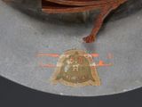 a brown hat with a bell on top of it