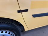 a close up of a yellow car parked on the side of the road